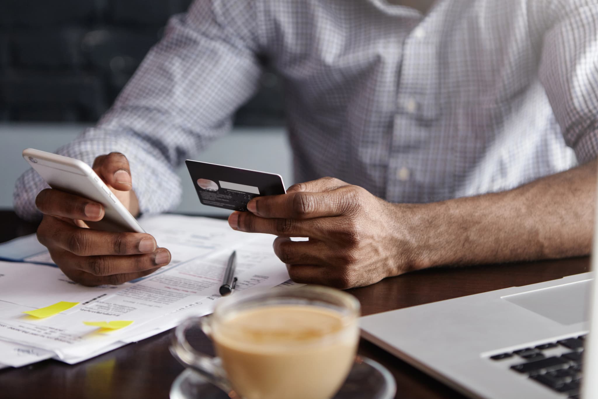 Man's hands holding mobile and credit card